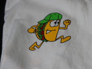 a shirt with a taco running on it